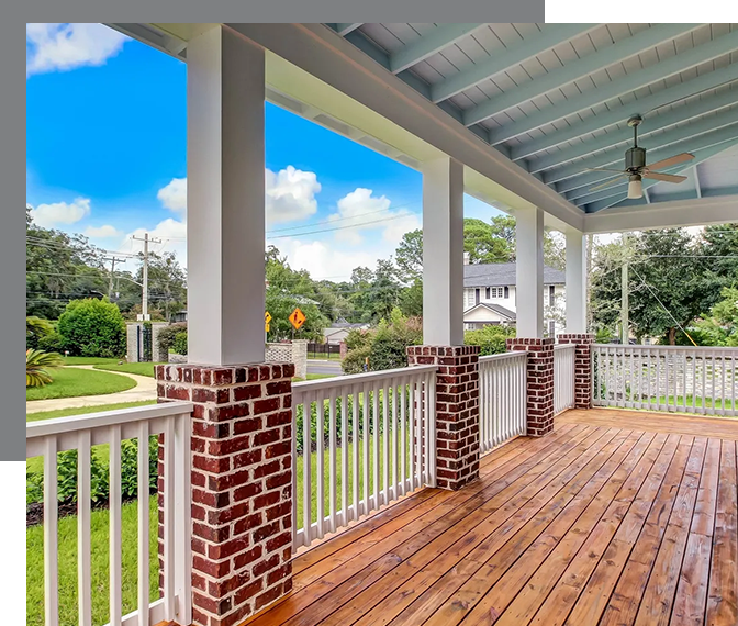 A porch with brick columns and white posts.